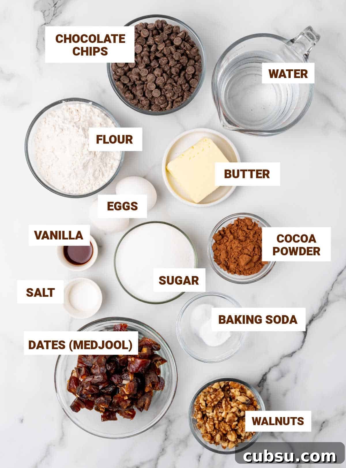 Decadent Chocolate and Date Cake Recipe for Moist Loaves 5 Bowls on white marble surface containing ingredients for chocolate date cake including walnuts, flour mixture, butter, eggs, sugar, cocoa powder, vanilla.