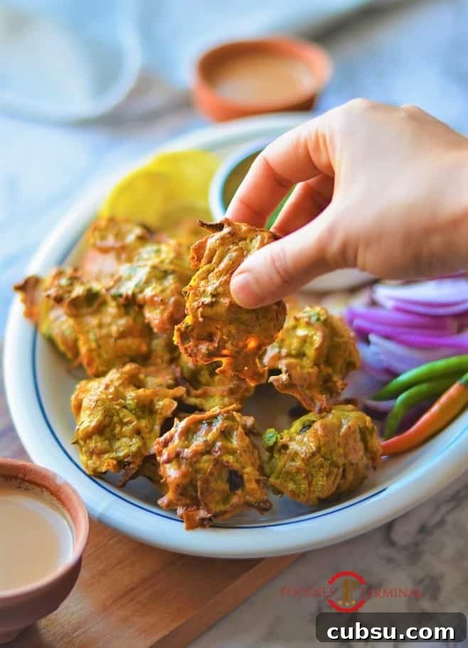 Chicken pakora recipe being lifted from the plate