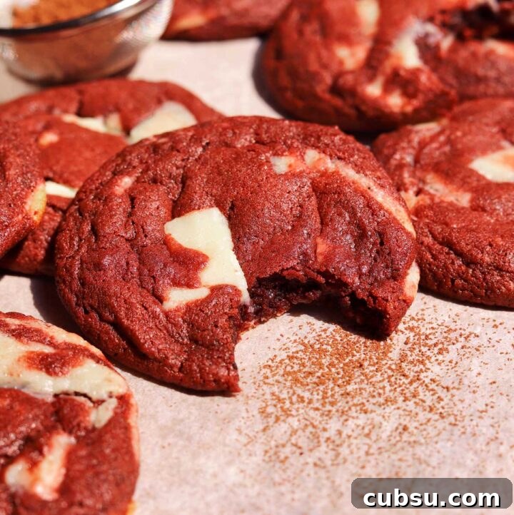 How to Make Classic Red Velvet Cookies with Cream Cheese Filling 4 red velvet cookies with bite on baking sheet