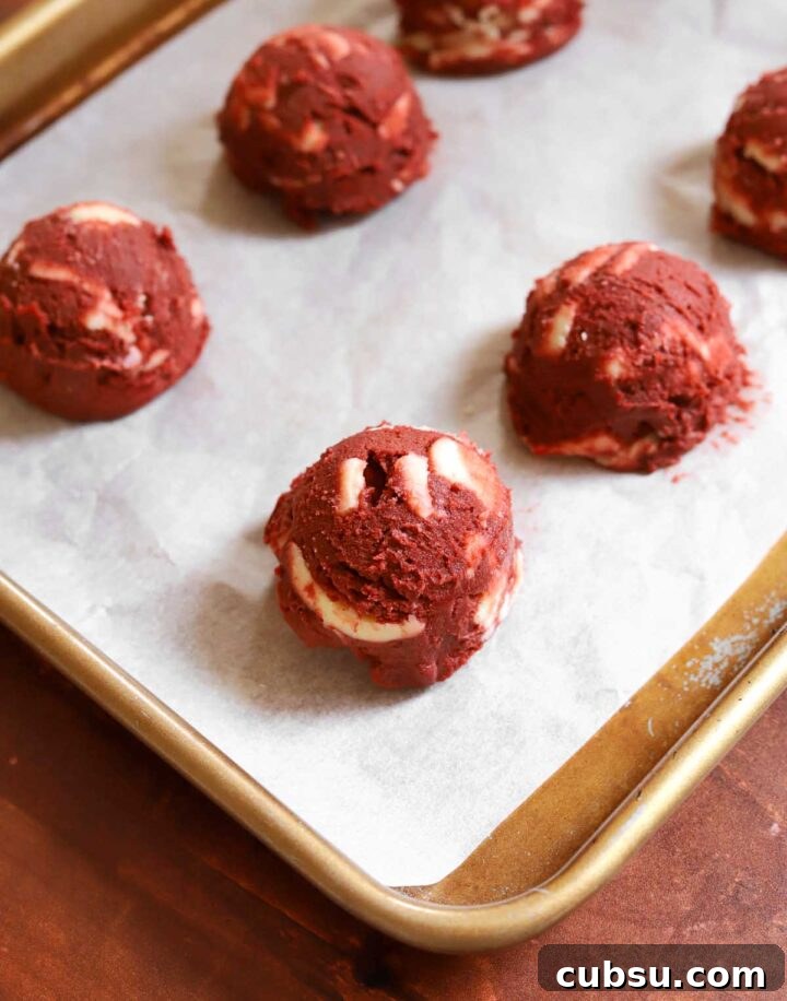 How to Make Classic Red Velvet Cookies with Cream Cheese Filling 6 red velvet cookie dough on parchment lined baking sheet before baking