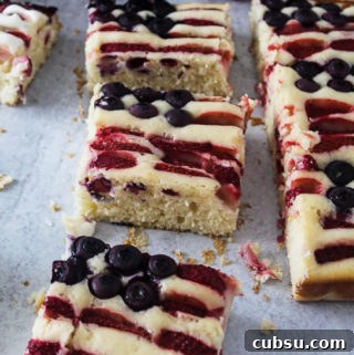 Red, White & Blue Fruit-Topped American Flag Cake Recipe 7 square pieces of white cake with blueberries and strawberries in the cake decorated as a flag and crumbs around it.