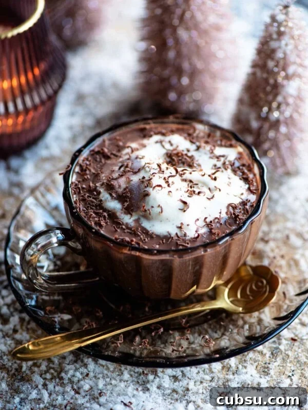 Hot chocolate in a glass mug with ice cream on top and fake snow around.