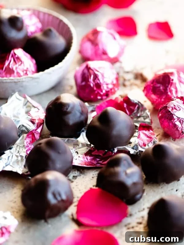 Homemade Italian baci chocolates on a travertine worktop with pink foil wrappers.