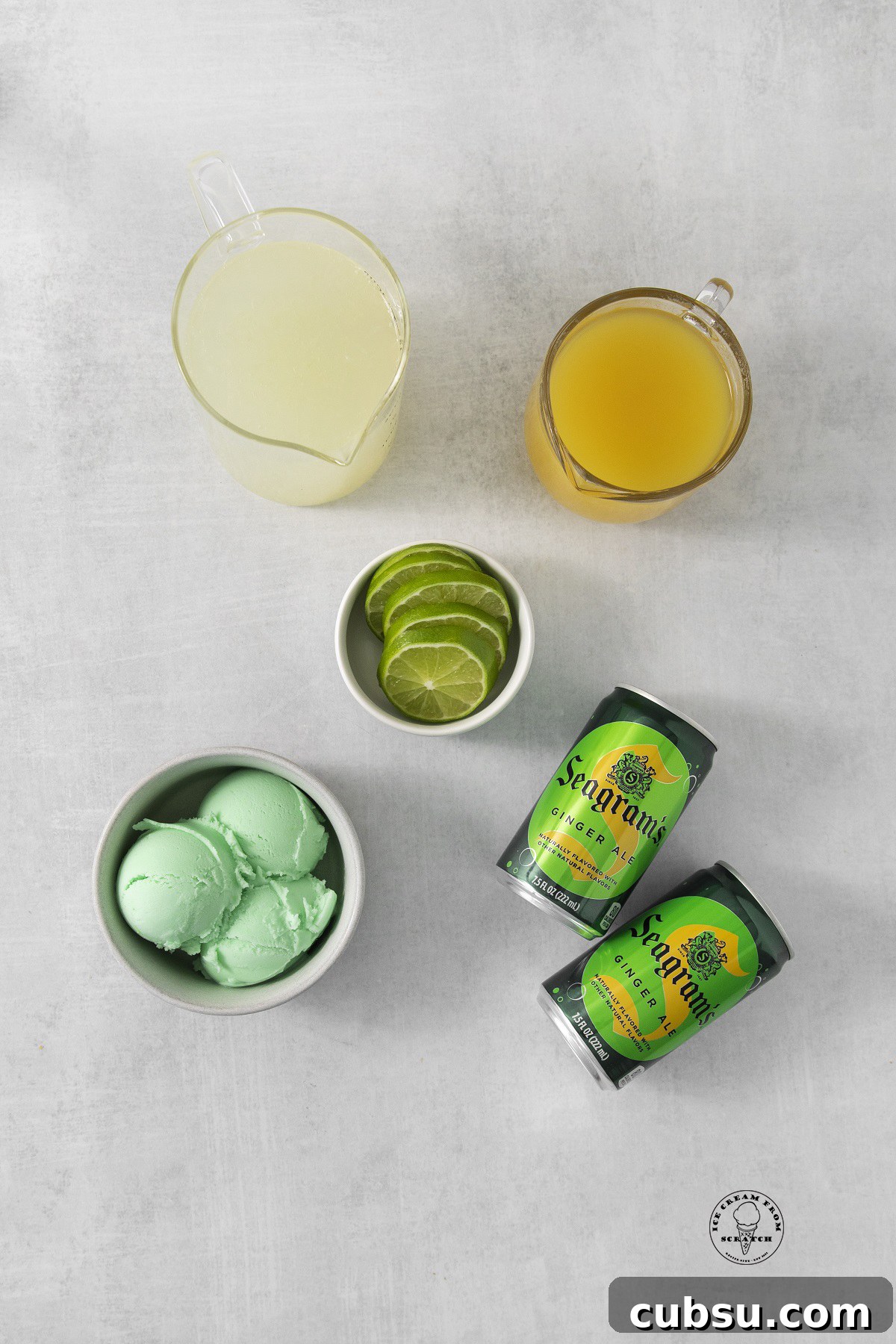 two cans of seagrams ginger ale on a counter with a bowl of lime sherbet, lime wedges, and juice for punch.