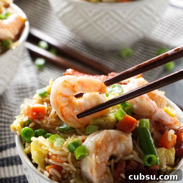 Blackstone Griddle Steak Fajitas: Flavorful Skillet Recipe 14 Chopsticks picking up some shrimp from a bowl of shrimp fried rice.