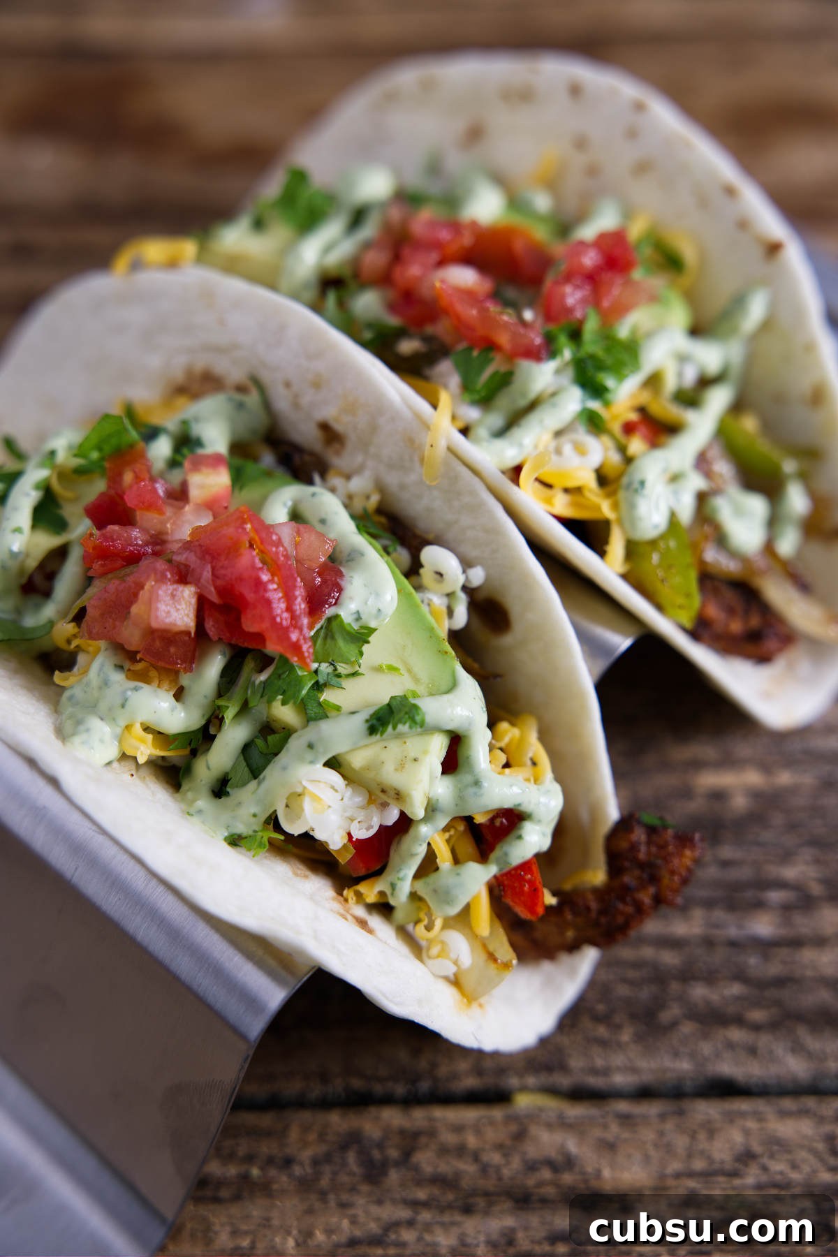 Blackstone Griddle Steak Fajitas: Flavorful Skillet Recipe 9 Delicious Blackstone Fajitas served in tortillas, garnished with avocado crema and vibrant bell peppers.