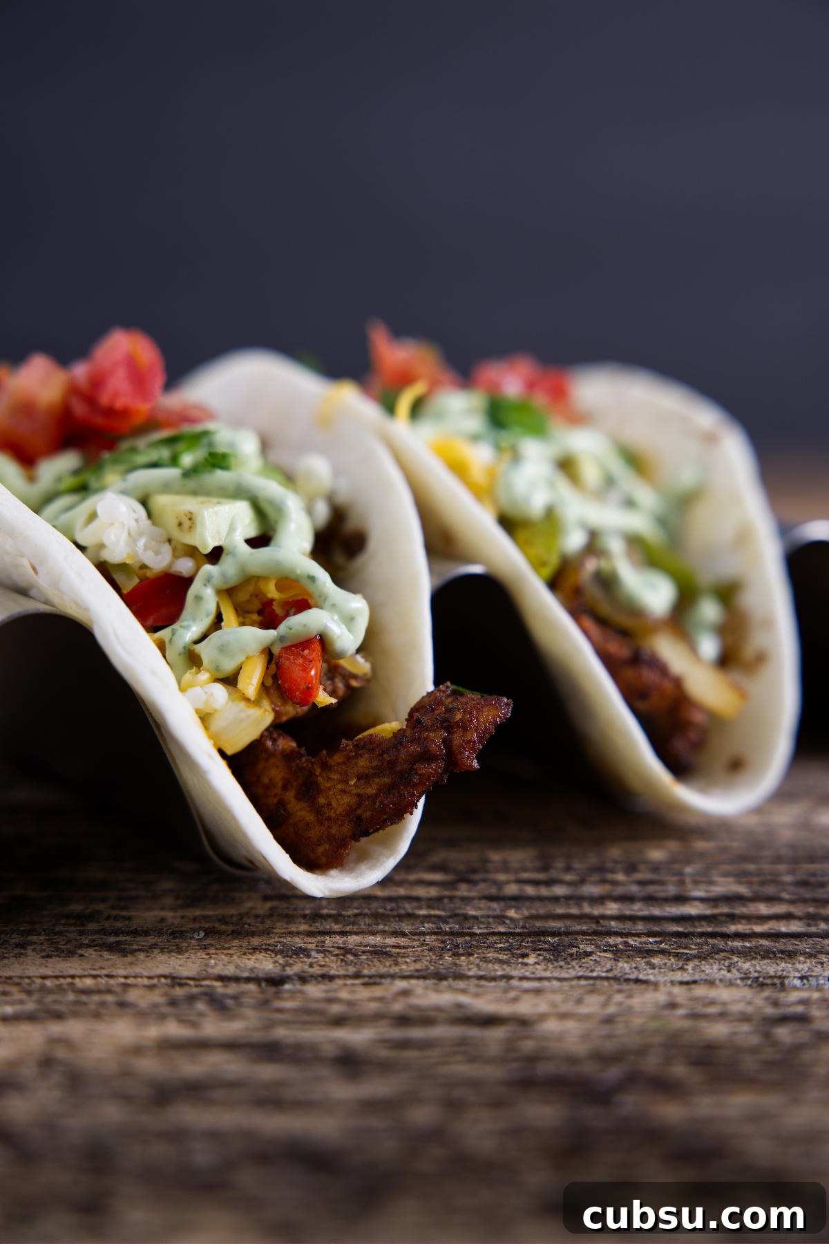 Blackstone Griddle Steak Fajitas: Flavorful Skillet Recipe 10 Two tacos filled with Blackstone fajita fixings and topped with a drizzle of avocado crema.