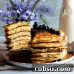 25 Creative Uses for Sourdough Discard: Recipes & Tips 4 A plate with a stack of sourdough discard pancakes with a slice of them taken out.