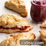 25 Creative Uses for Sourdough Discard: Recipes & Tips 6 Scones with a jar of raspberry jam and one scone with jam inside.