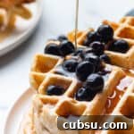 25 Creative Uses for Sourdough Discard: Recipes & Tips 9 A stack of sourdough waffles with blueberries and syrup.
