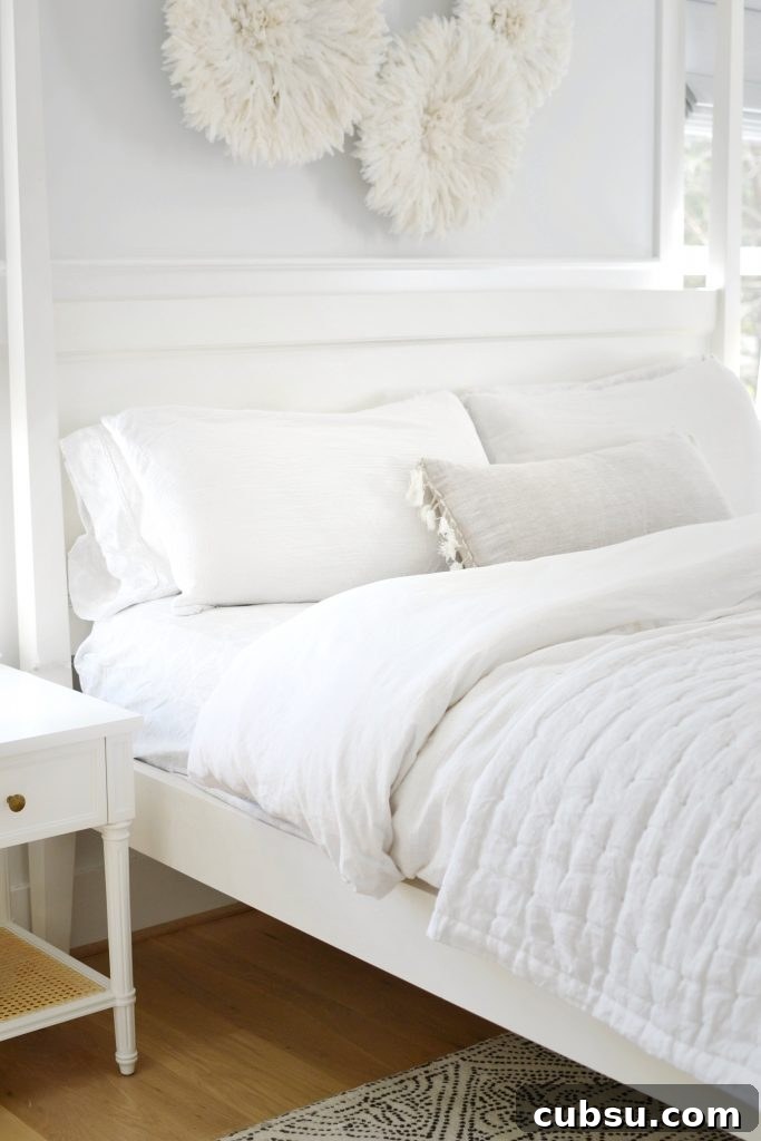 a white bed with white bedding on it