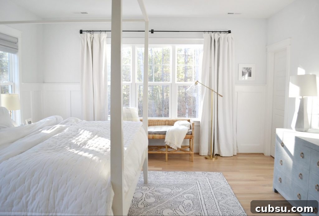 shore bench in a neutral, white bedroom with big windows