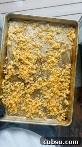 Crispy Oven and Air Fryer Rice: Step-by-Step Guide for Crunchy Rice 6 Someone holding a baking sheet of cooked crispy rice with an oven mitt.