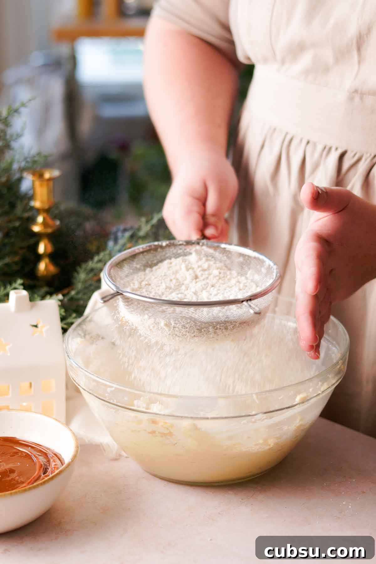 sifting dry ingredients into bowl of creamed wet ingredients