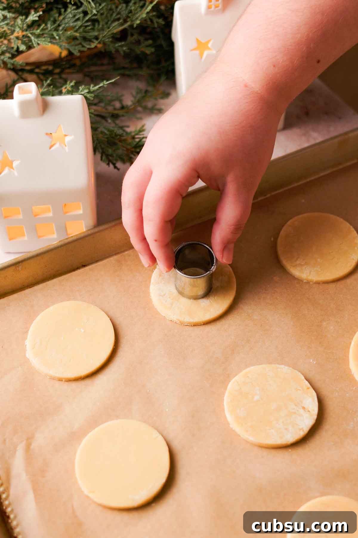 cutting middle of cookies out with small round cookie cutter