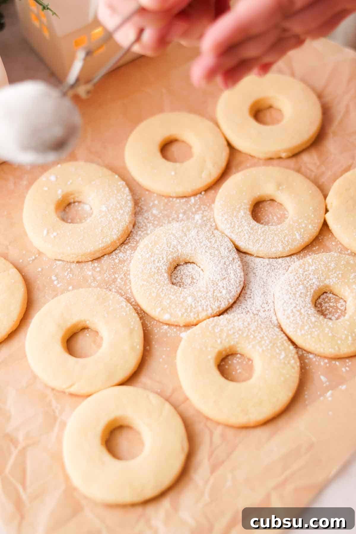 dusting cookies with holes cut out with powdered sugar