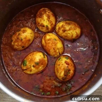 egg masala in a pot, garnished with coriander leaves.