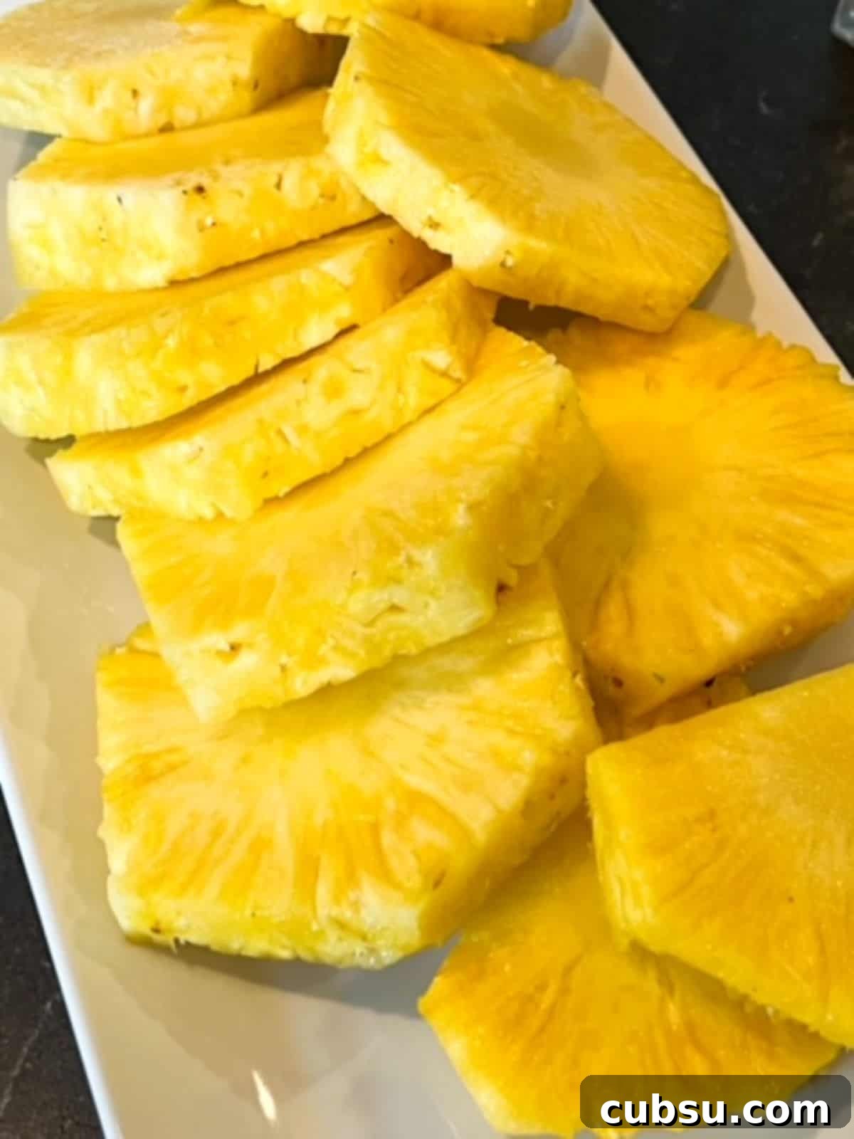 How to Choose a Ripe, Sweet Pineapple: Expert Tips for Picking One 4 Peeled and sliced pineapple rings with the core still in each ring.