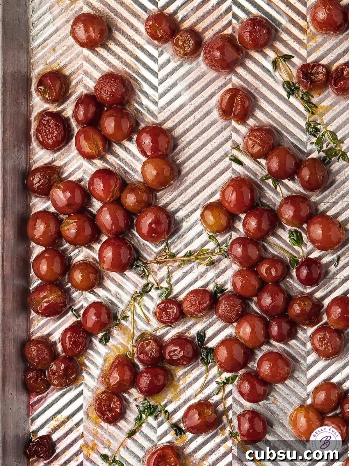 Roasted Grapes Recipe: Sweet Caramelized Grapes for Savory Dishes 3 roasted red grapes with fresh thyme sprigs on baking sheet