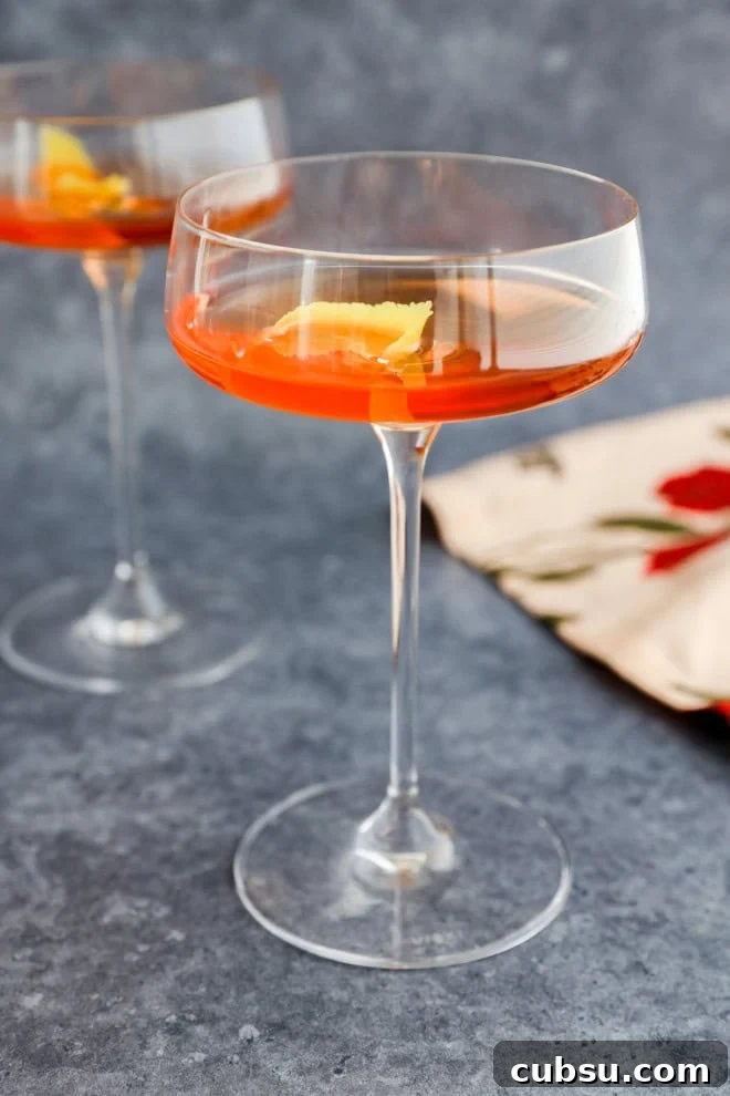 pink gin cocktail in coupe glasses with lemon twist
