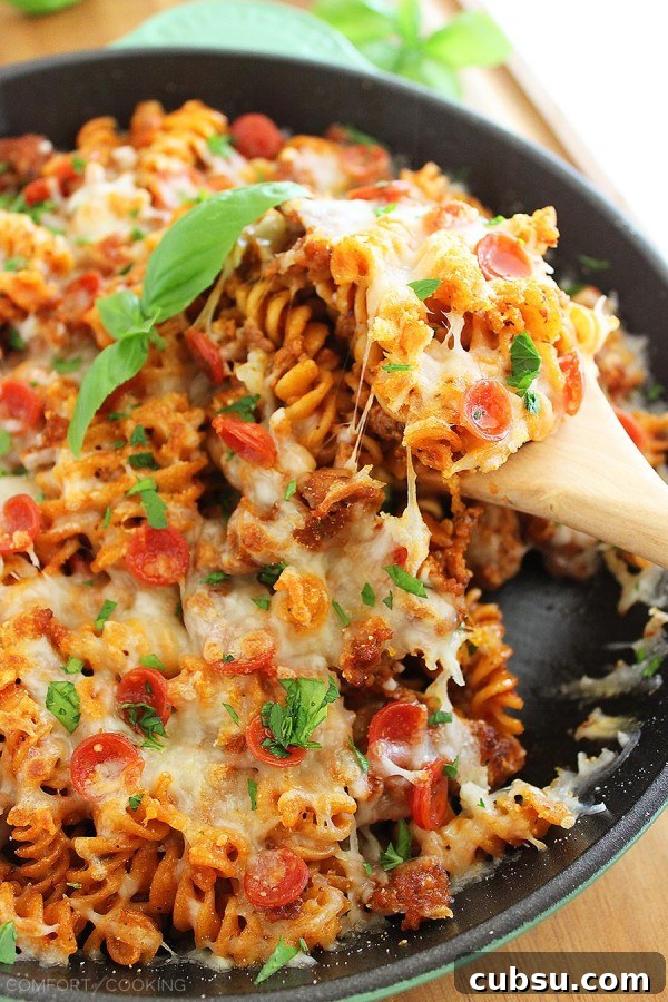 Cheesy Skillet Pizza Pasta – Try this saucy, scrumptious pizza-meets-pasta dish for a fun weeknight meal! It's easily made from scratch in one skillet! | thecomfortofcooking.com