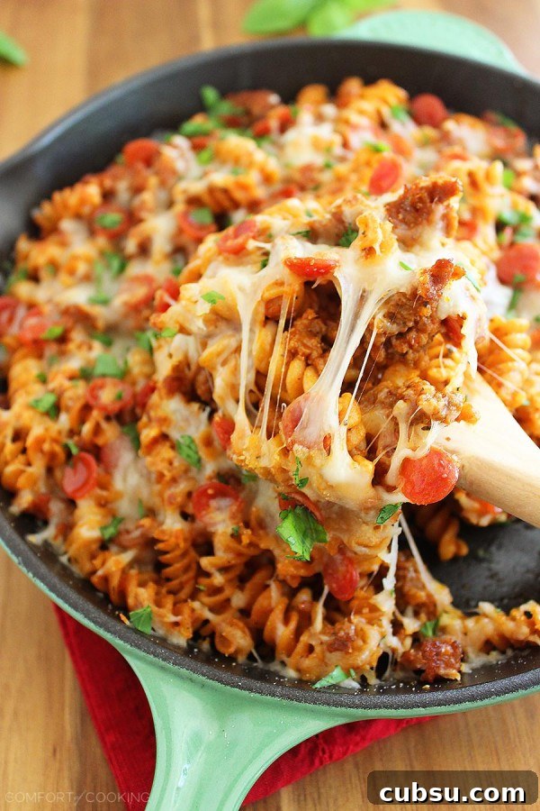 Cheesy Skillet Pizza Pasta – Try this saucy, scrumptious pizza-meets-pasta dish for a fun weeknight meal! It's easily made from scratch in one skillet! | thecomfortofcooking.com