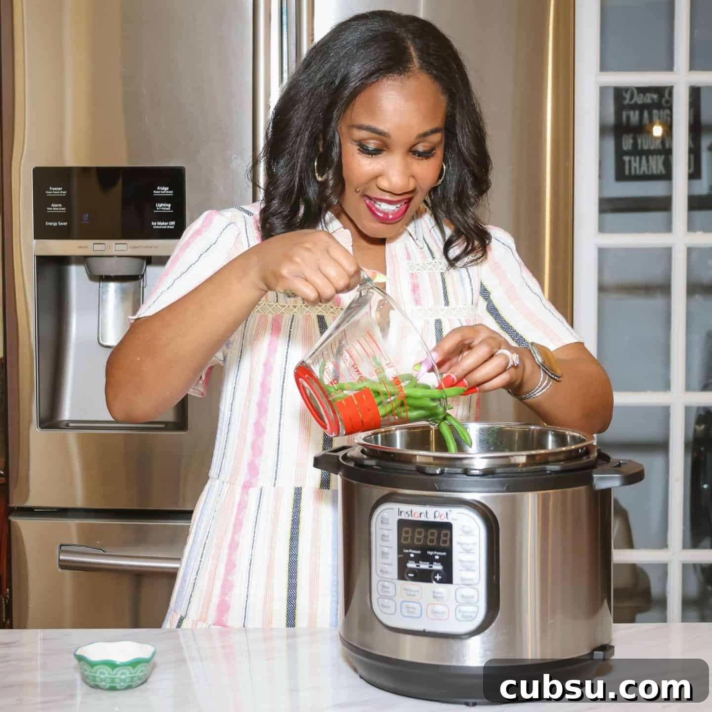 Shaunda Necole adding fresh green beans to an Instant Pot pressure cooker to make soul food green beans with layered soulful seasoning.