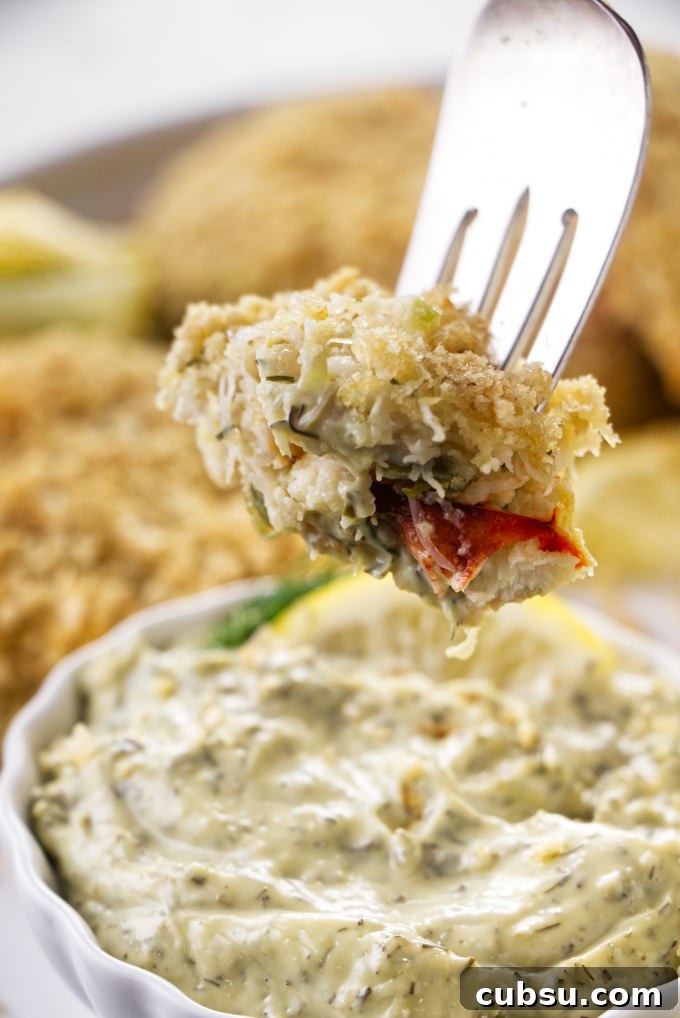 Crispy Dungeness Crab Cakes with Lemon Aioli Recipe 3 Dipping a crab cake in tartar sauce.