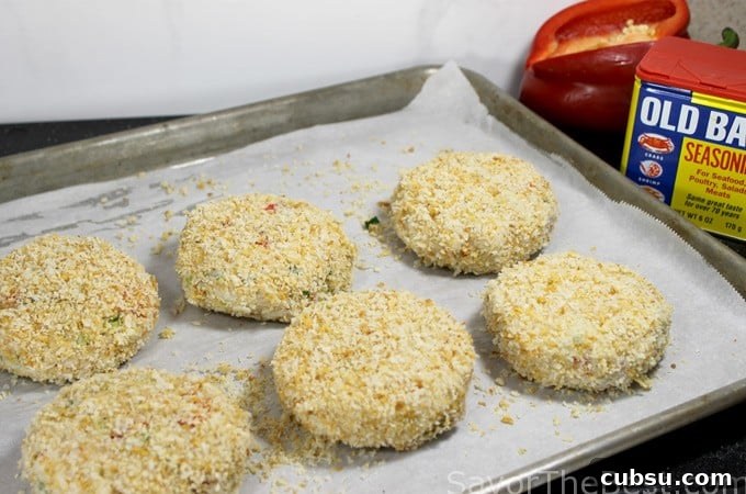 Crispy Dungeness Crab Cakes with Lemon Aioli Recipe 7 Panko breaded crab cakes on a baking tray.
