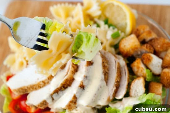 Picking up easy Bowtie Chicken Caesar Salad with a silver fork.