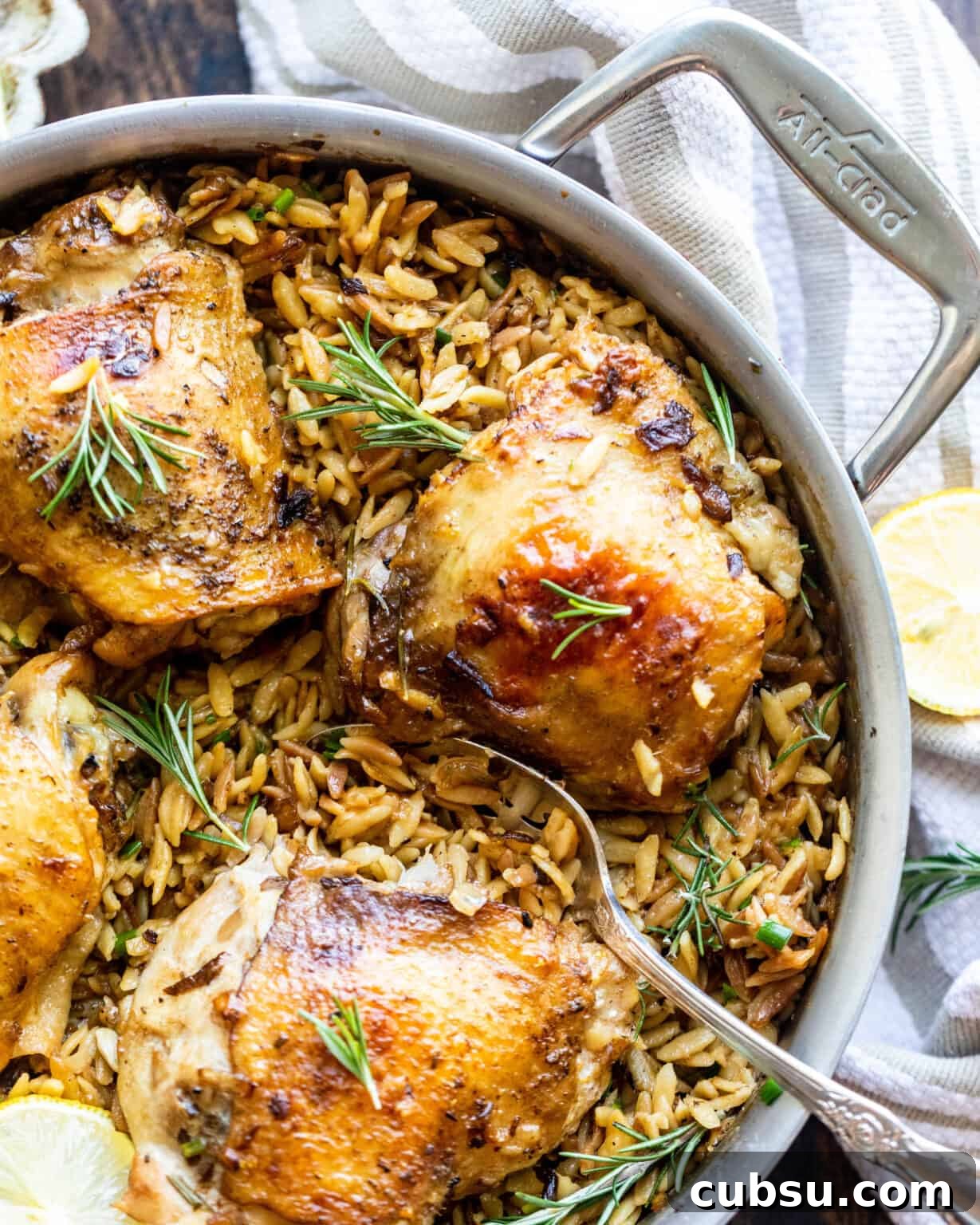 Rosemary Roasted Chicken with Creamy Parmesan Orzo 4 rosemary chicken with parmesan orzo in a pan with a spoon and lemons
