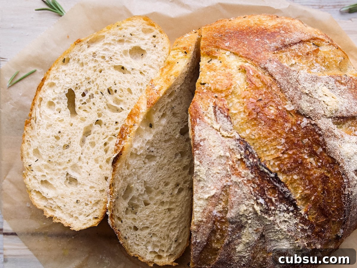 Rosemary Sea Salt Sourdough Bread Recipe for Crispy Crust 3 A loaf of rosemary sourdough bread with a few slices cut into it