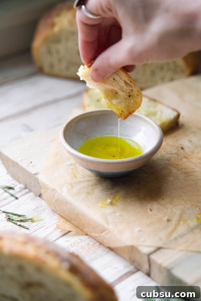 Rosemary Sea Salt Sourdough Bread Recipe for Crispy Crust 8 Dipping rosemary bread into olive oil