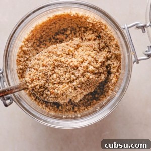 How to Make Pecan Flour at Home for Baking and Paleo Recipes 7 homemade pecan flour in a jar heaped on a silver spoon.