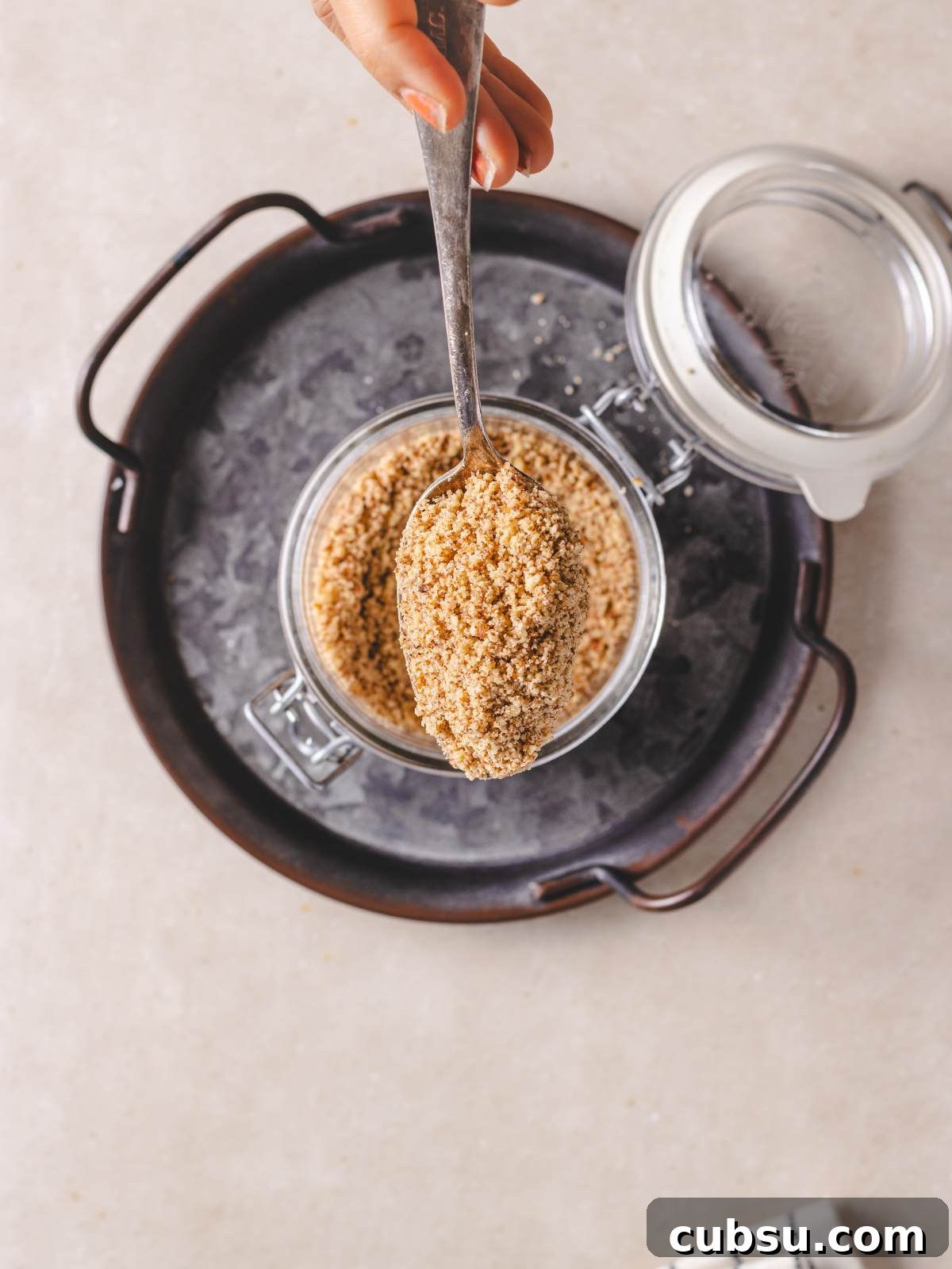 How to Make Pecan Flour at Home for Baking and Paleo Recipes 5 Grounded pecans in a jar on a white surface.