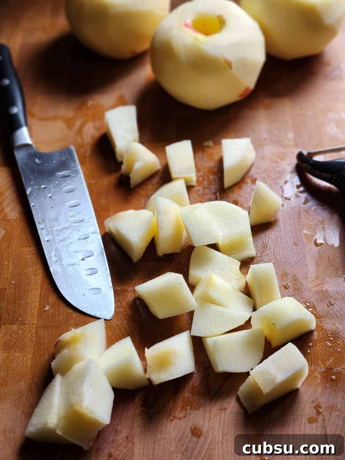 Chopped apples in cubes on a cutting board.