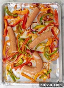 sausages and peppers on baking sheet ready to be cooked