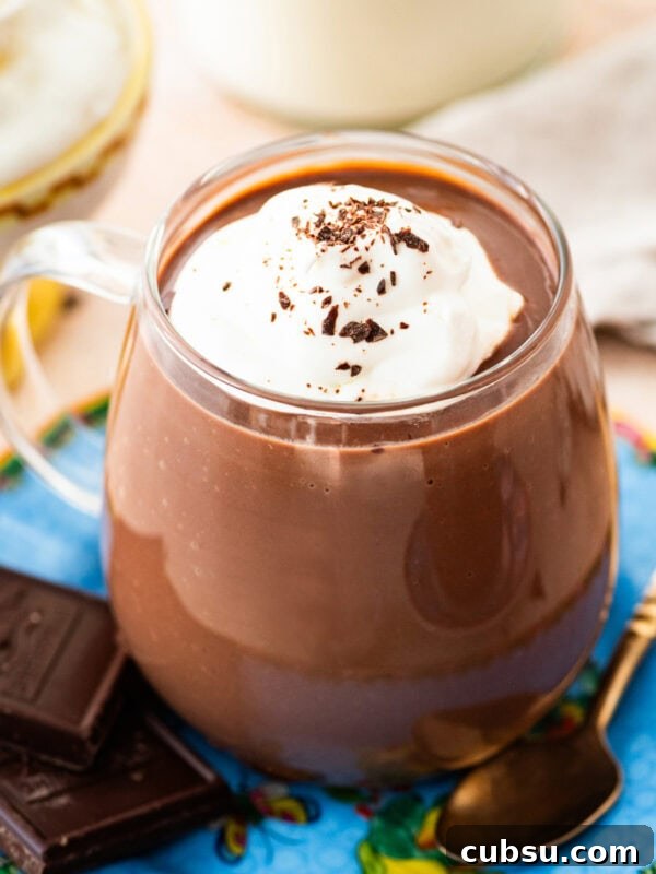 Christiane’s Classic Chocolate Mousse Recipe 4 glass mug of hot chocolate with whipped cream and shaved chocolate.