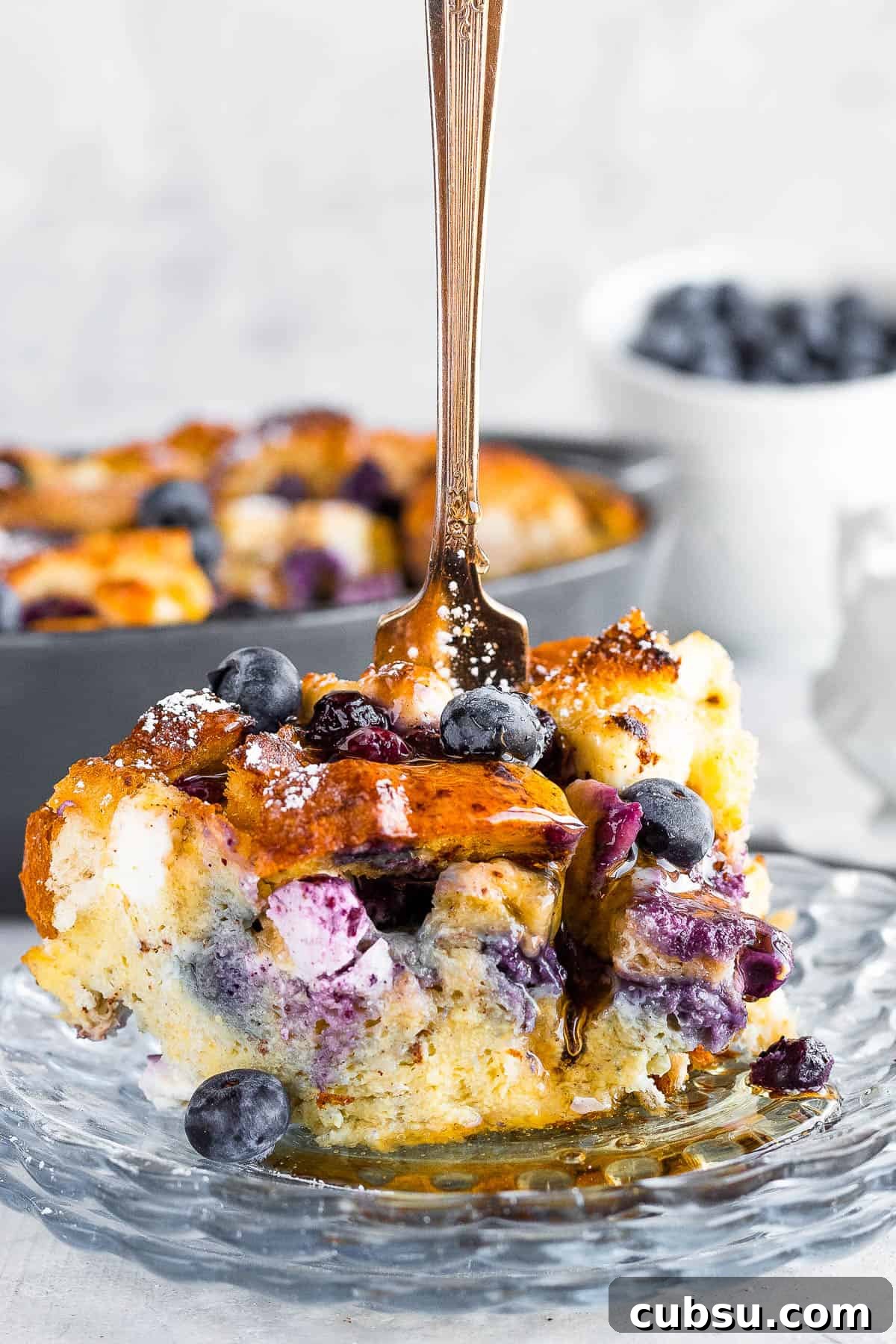 A Piece of Blueberry Casserole with a Fork Sticking Upright Into it