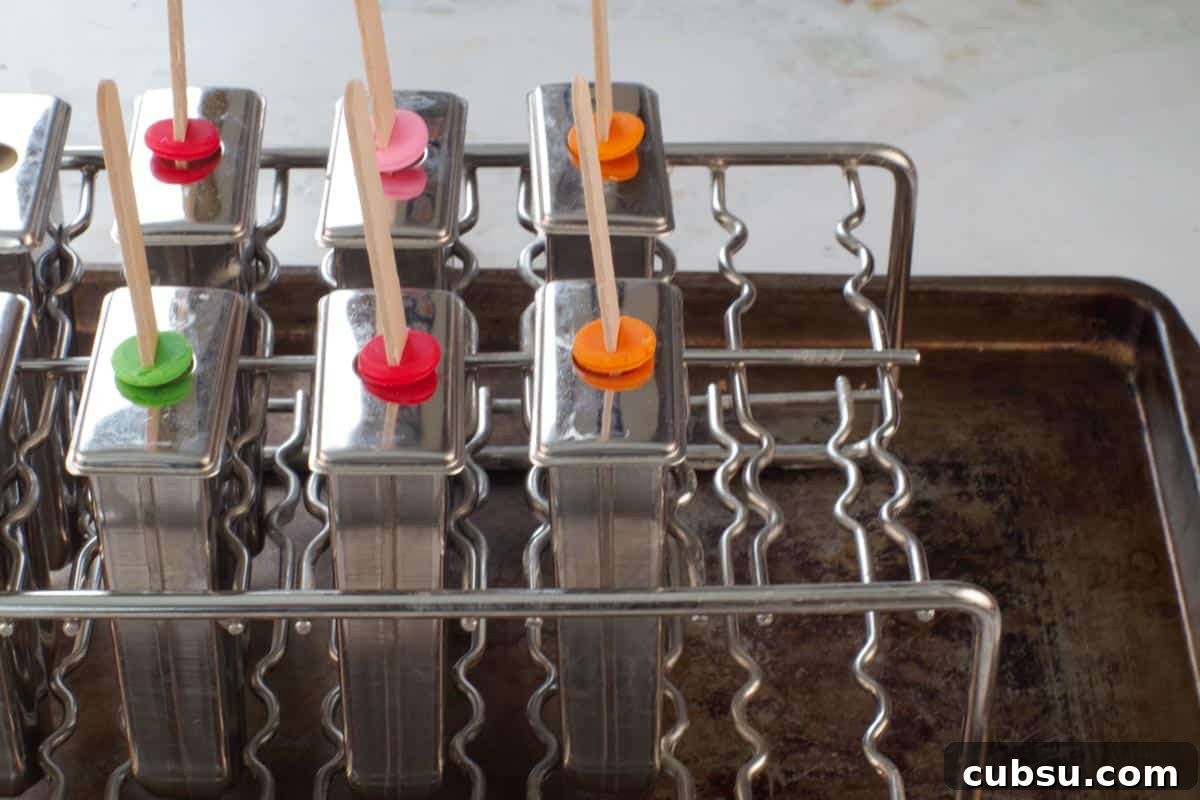 popsicle molds in holder on old sheet pan.