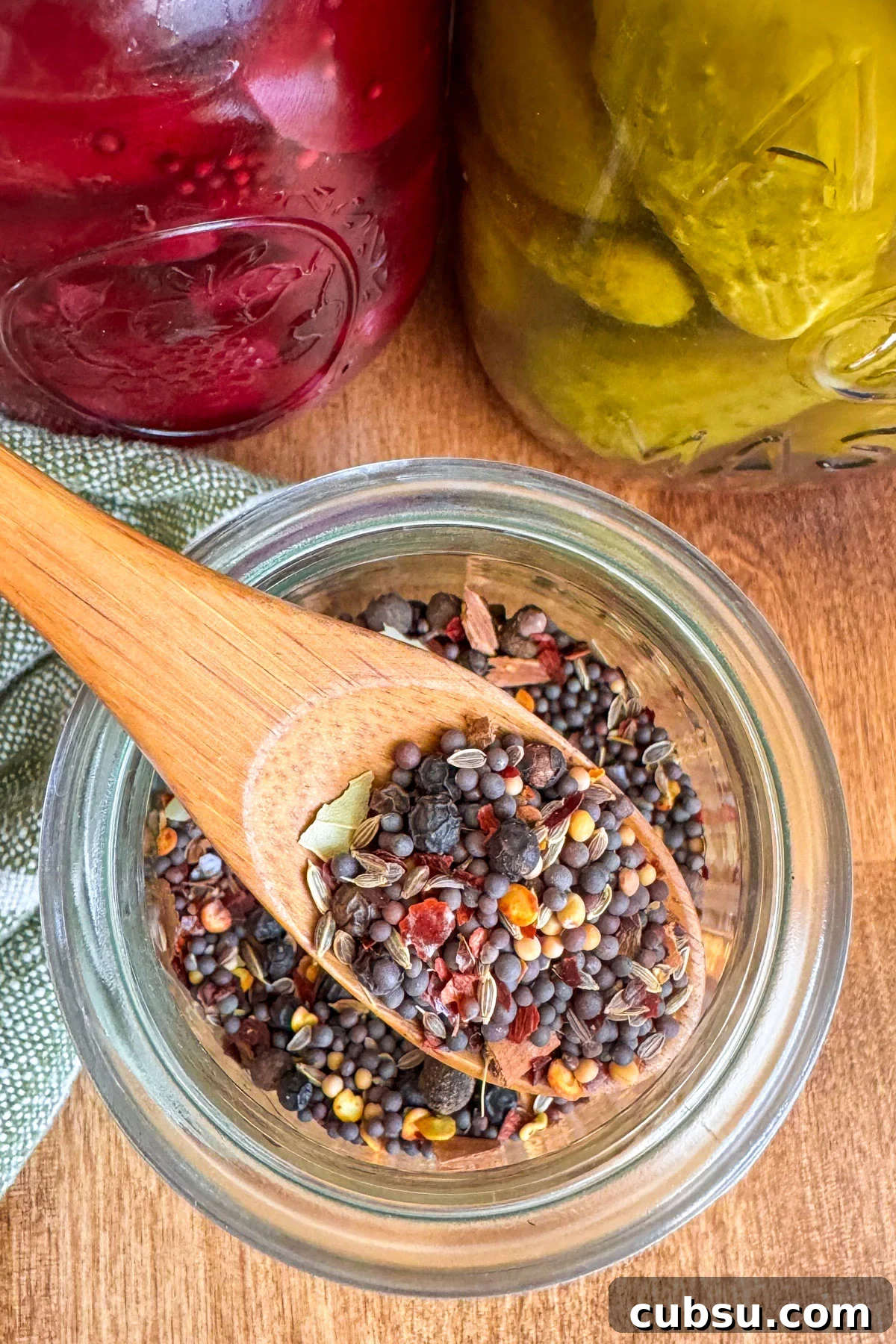 Customizable Pickling Spice Blend Recipe for Every Jar 2 pickling spice recipe mixed in jar with wooden spoon