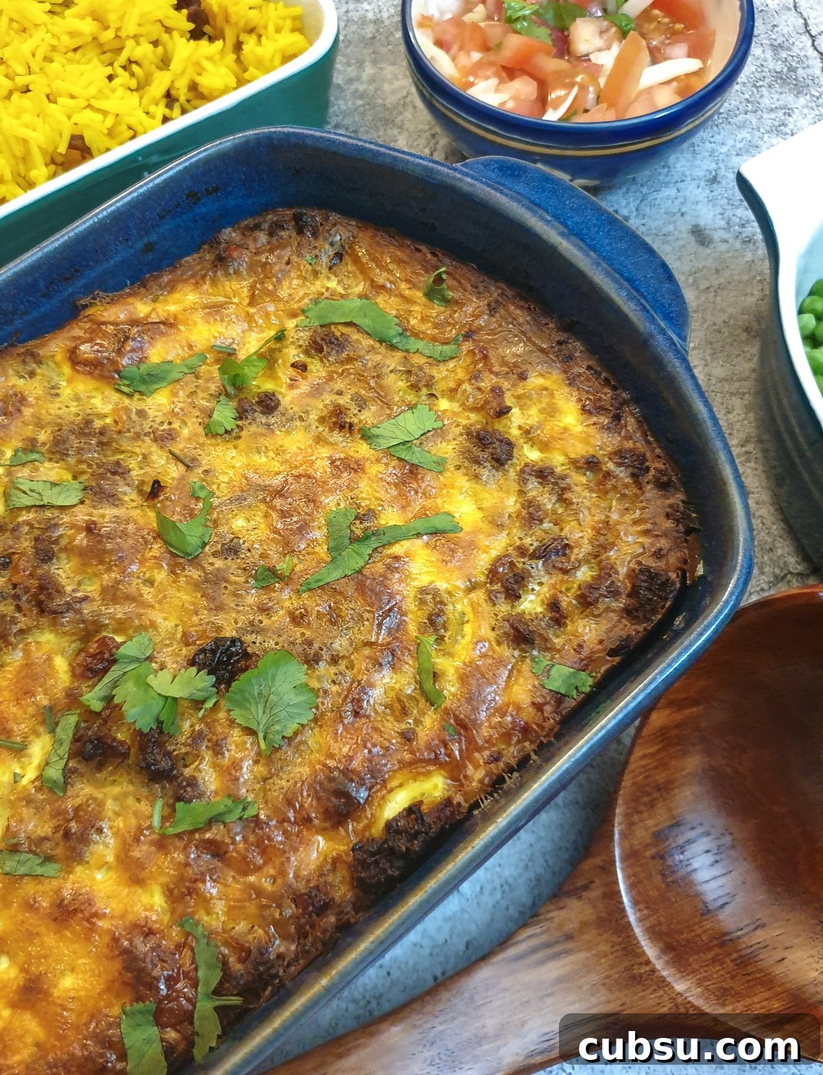 Close up of a dish of bobotie garnished with chopped coriander.
