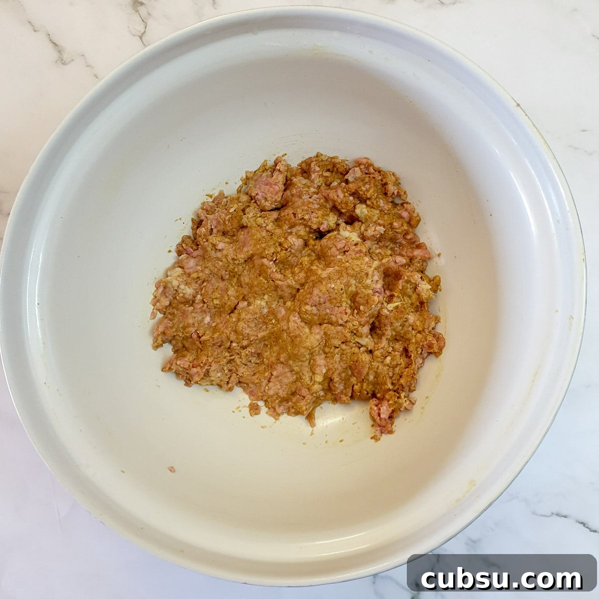 Bobotie mince mixed with spices and ready for frying.
