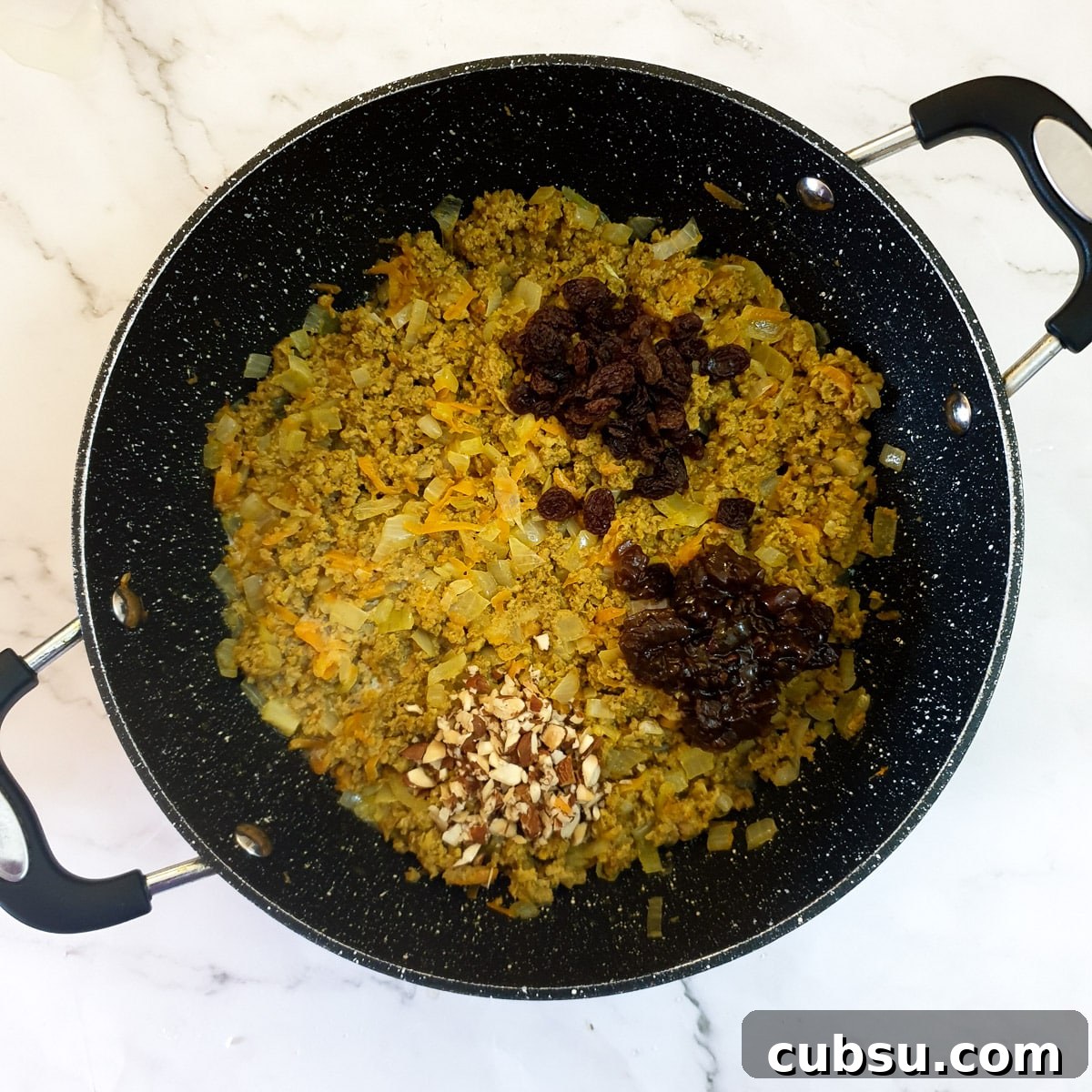 Sultanas, chutney and chopped almonds added to the bobotie mixture.