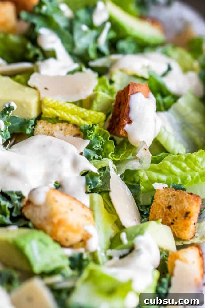 Kale Caesar Salad close-up. Close up shot of kale Caesar salad with dressing over the top.