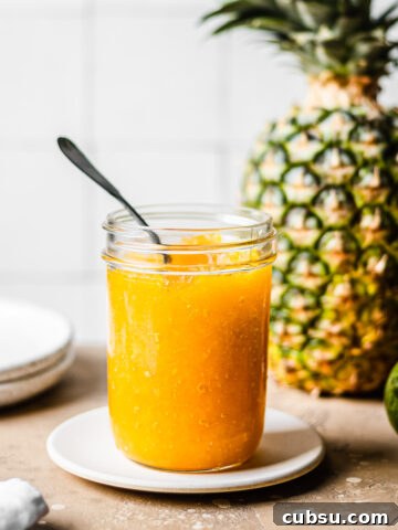 A mason jar of golden yellow jam.