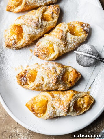 Baked pastries on white parchment on a white ceramic plate.
