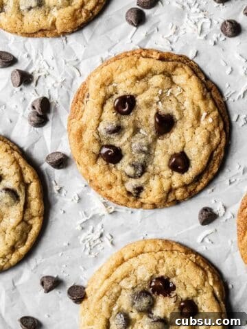 Baked coconut chocolate chip cookies on parchment paper.