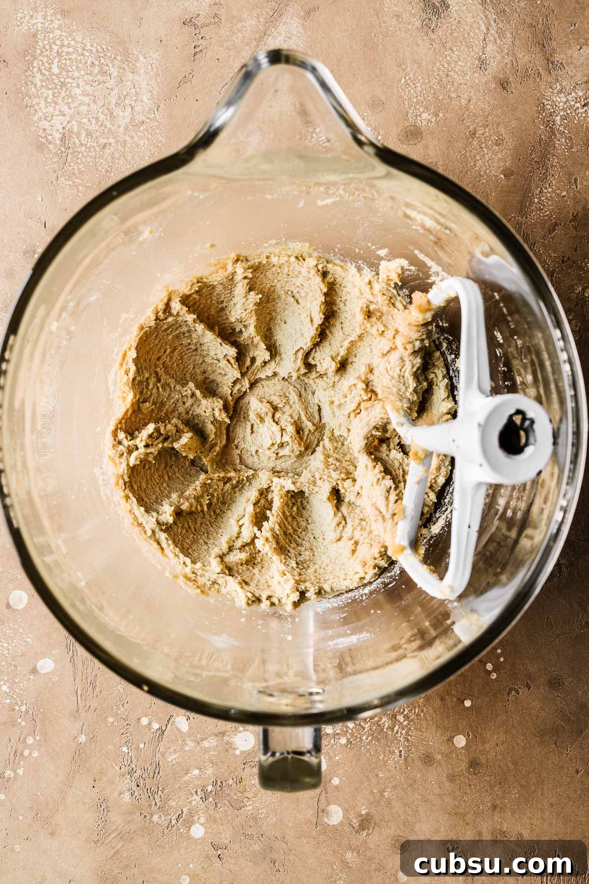 Creamed butter and sugar in a clear glass mixing bowl.
