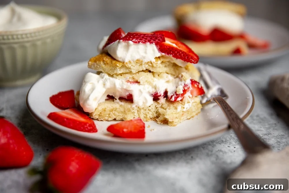 Close up of a half-eaten gluten free strawberry shortcake on a plate. 